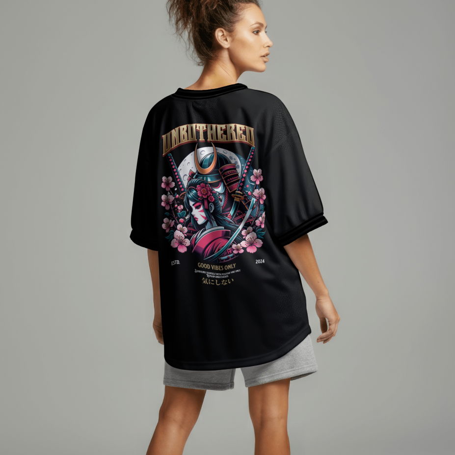 Person wearing a black oversized t-shirt with a colorful graphic design on the back, standing against a plain background.